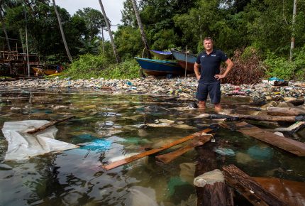 Marco Simeoni in the ocean with plastic trash in Palau Gaya, Borneo